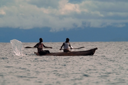 Two people use a canoe to catch catfish in Lake Malawi