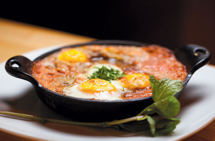 Eggs poached in red sauce made with spices including coriander